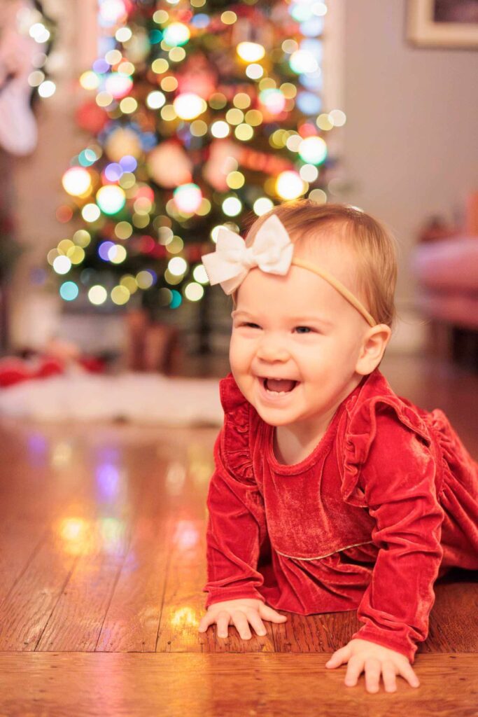 Baby crawls in front of Christmas tree during Main Line Baby photographer session