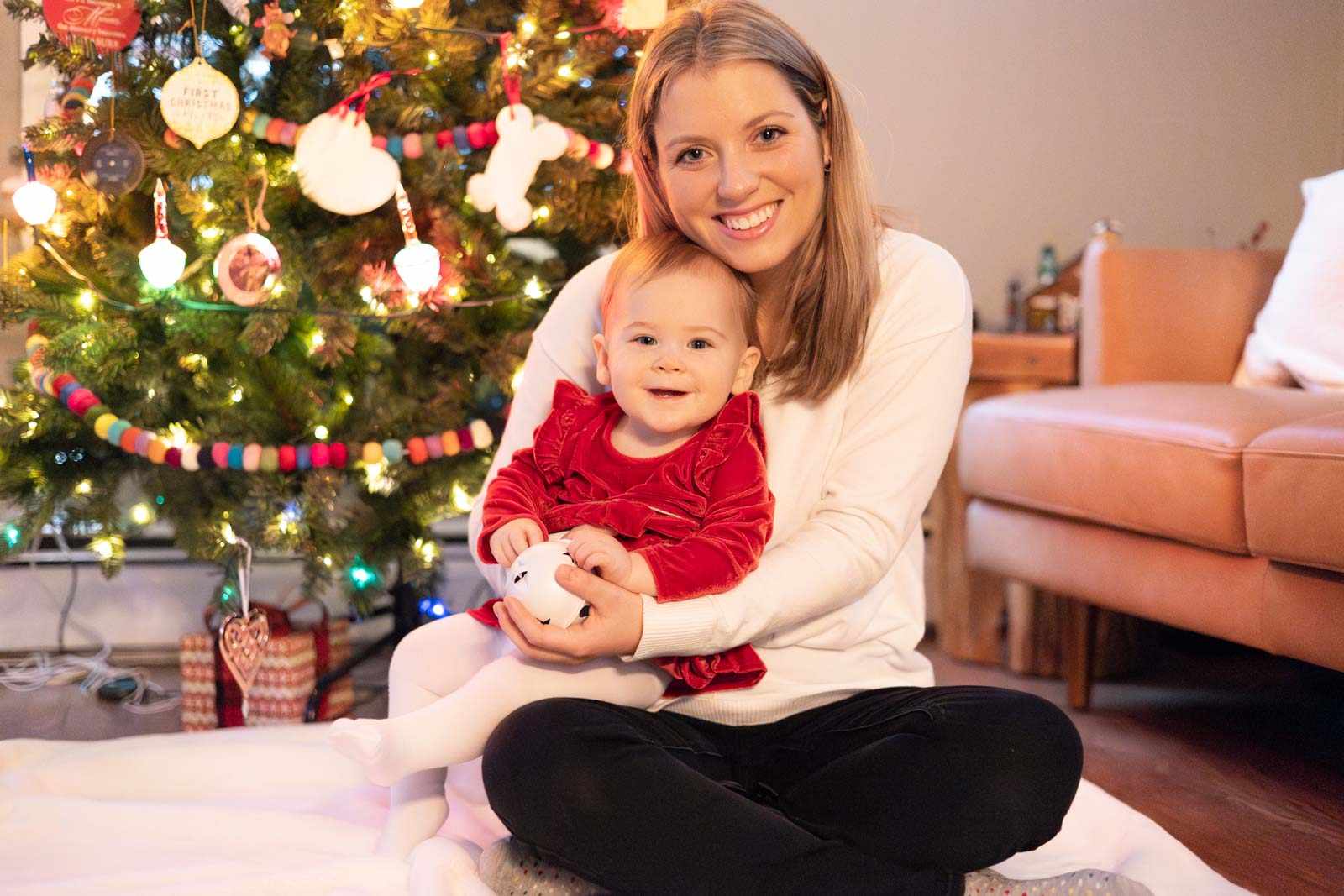 Mother and baby pose in front of tree during in-home on photography session on Philadelphia's Main Line