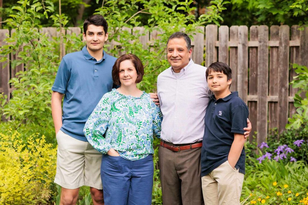 Family poses in garden for family photo session in Lower Merion, PA