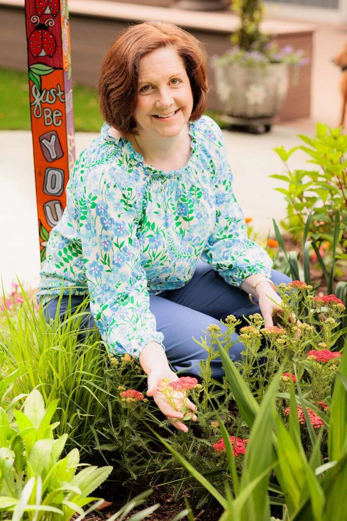 Woman sits in Lower Merion garden for photo session headshots