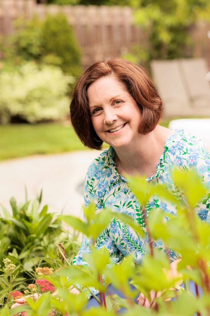 Woman poses with green plants for headshots