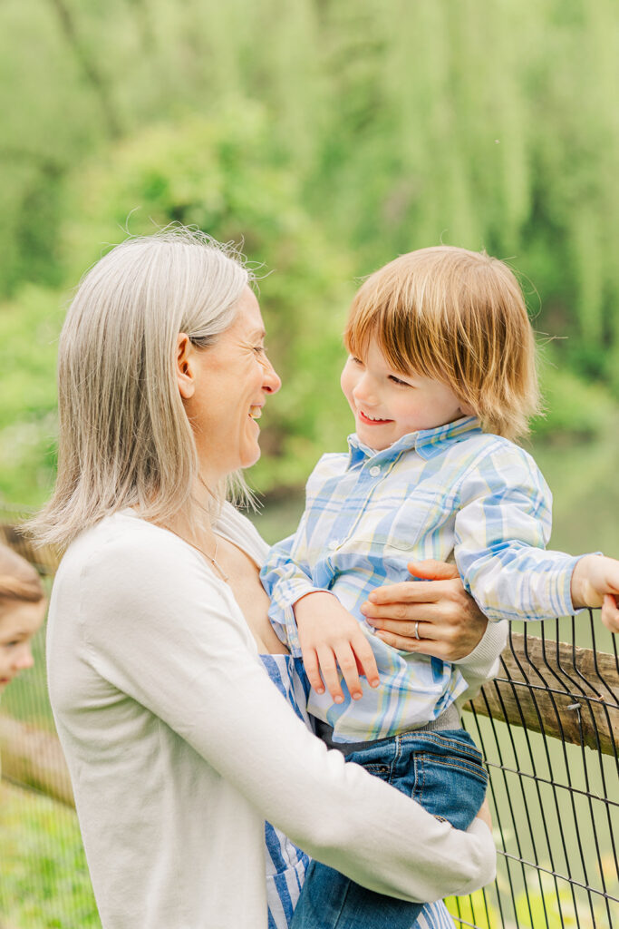 Mother and son smile at each other next to duck pond, Haverford, PA.