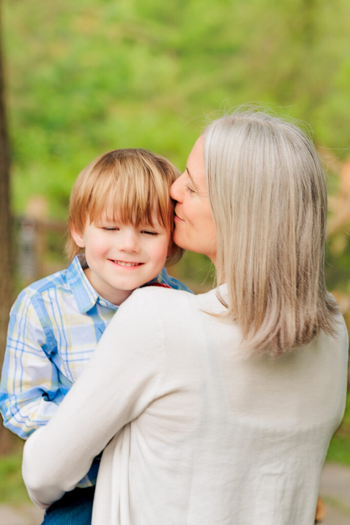 Mother kisses young boy's head while carrying him away, Haverford, PA.