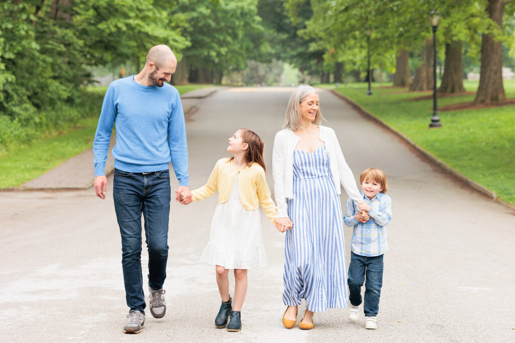 Haverford family walks down path while looking at one another.