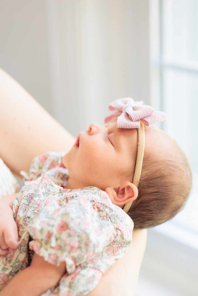 newborn baby sleeps in mom's arms