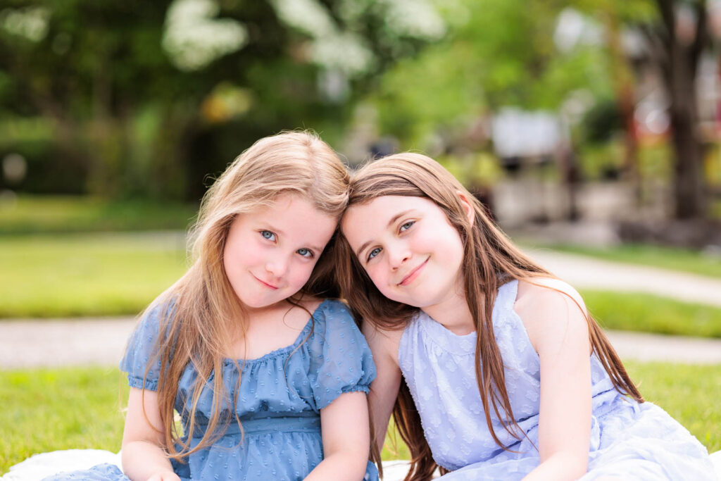 Two girls dressed in different shades of blue demonstrate coordinating colors for a phot session.