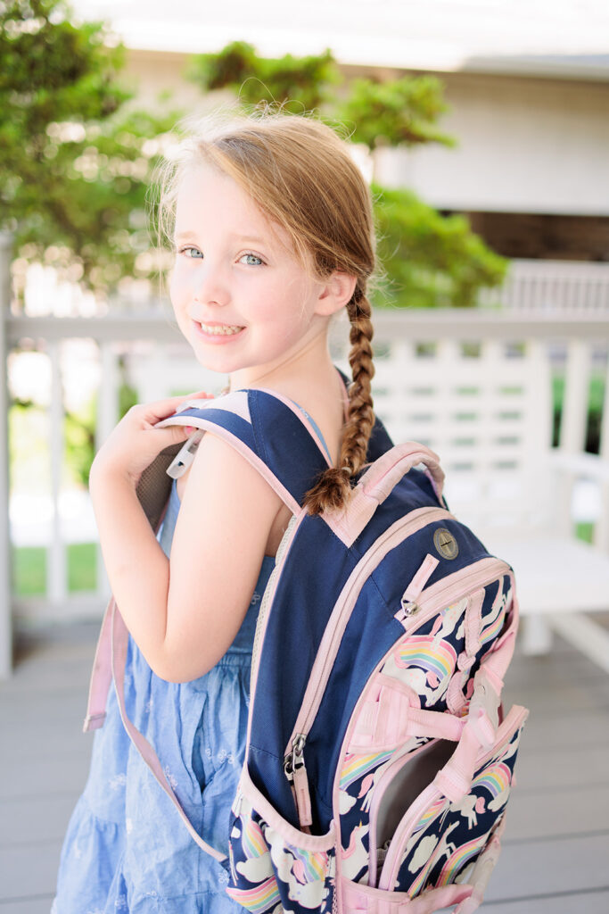 Girl poses with backpack for back-to-school photo.