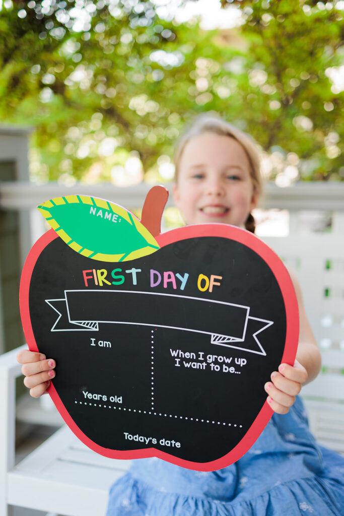 Child holds back to school sign for first day of school photo